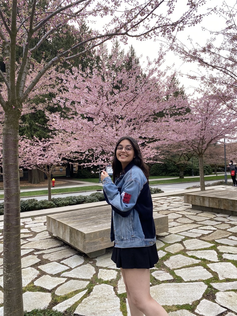 Dishti standing under cherry blossoms
